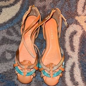 Brown sandals strap around the ankle with zipper in back